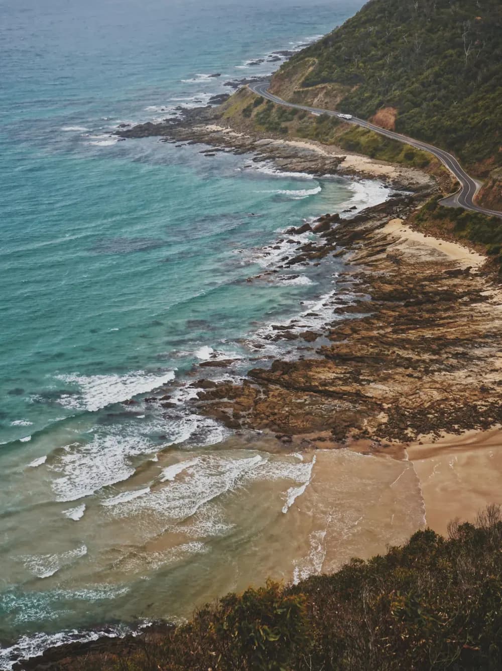 The Great Ocean Road curving above blue ocean